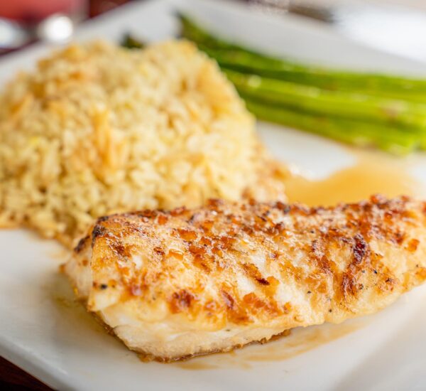 Breaded fish with rice and veggies on a plate