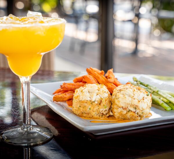 Crab cakes with sweet potato fries and asparagus and a cocktail